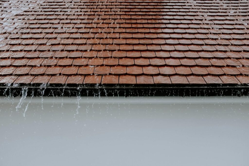 Rainwater flowing down roof shingles maintained by a roofing contractor in Royal Palm Beach.